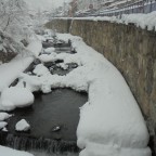 Snow piling up by the river in Arinsal